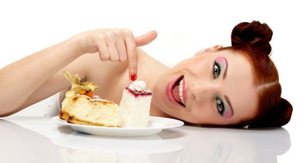 Junge Frau vor einem Teller mit Torte