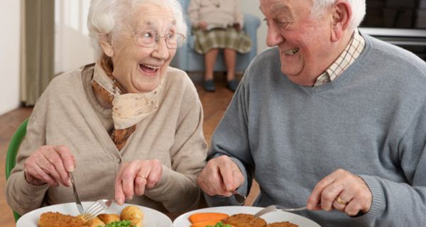 Seniorenpaar isst zu Mittag und strahlt sich an