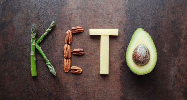 Das Wort "Keto", gelegt in Spargel, Nüssen, Käse und Avocado.