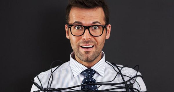 Mann mit Brille ist mit Elektrokabeln eingewickelt bzw. gefesselt