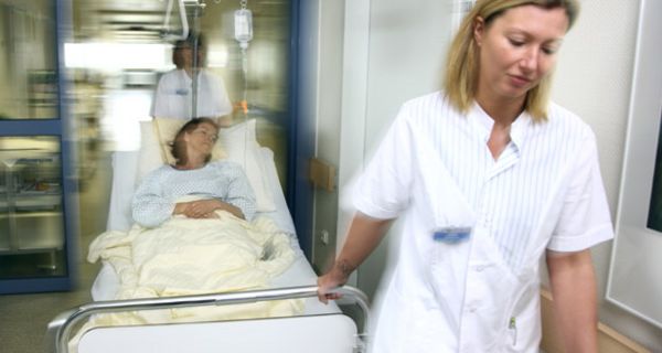 Krankenschwester zieht Krankenbett
