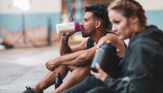 Ein sportliches Paar, dass sich ausruht und trinkt.