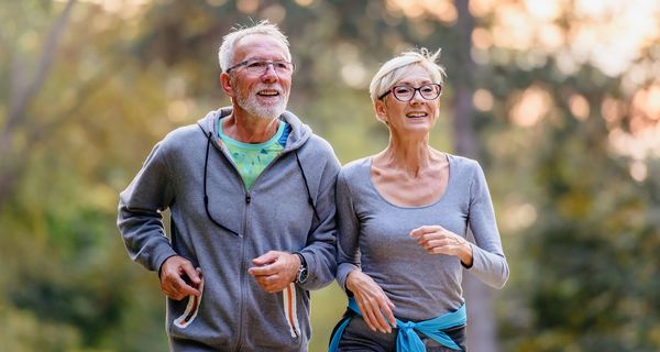 Senioren-Paar joggt im Wald