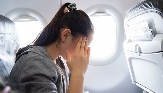Müde Frau im Flugzeug