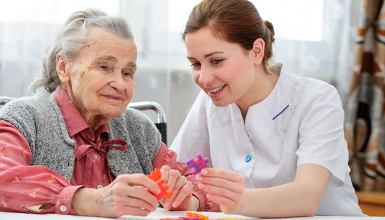 Pflegerin, kümmert sich um eine ältere Frau.