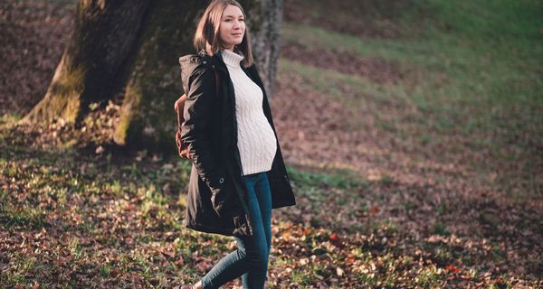 Schwangere Frau im Herbst, geht Spazieren.