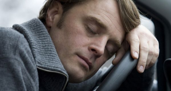 Mann schläft am Steuer eines Autos