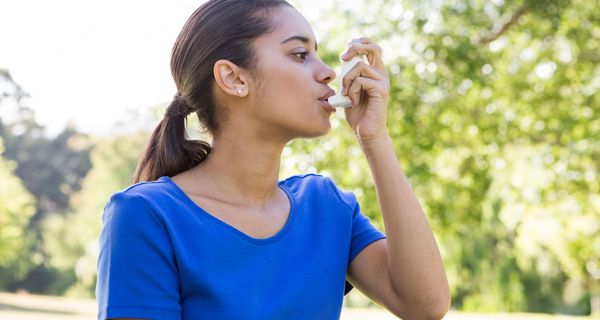 Junge Frau nutzt Asthmaspray.