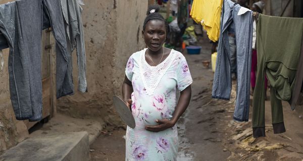 Schwangere dunkelhäutige Frau in einem Slum.