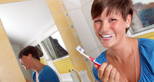 Frau putzt sich die Zähne.