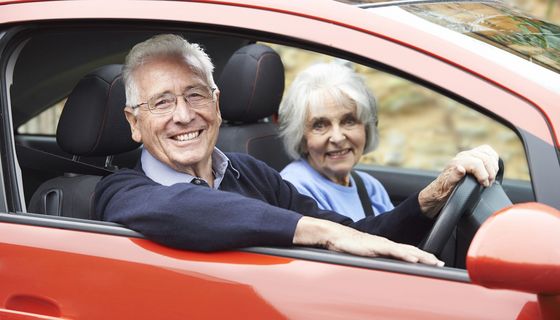 Älteres Paar sitzt im Auto.