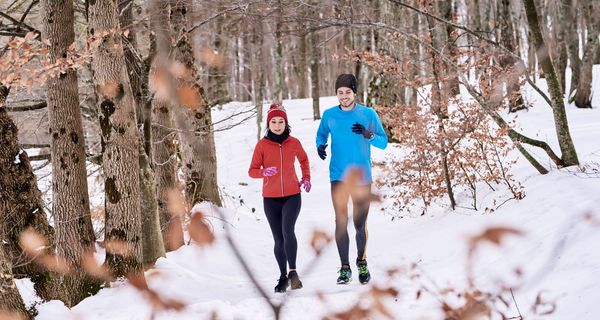 Mann und Frau, joggen bei Schnee.
