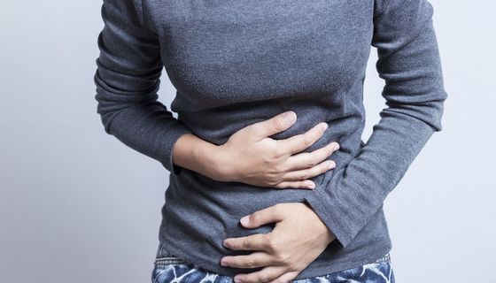 Frau, legt ihre Hände auf ihren Bauch.