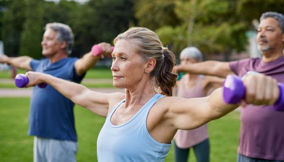 Gruppe älterer Sportler beim Krafttraining im Park.