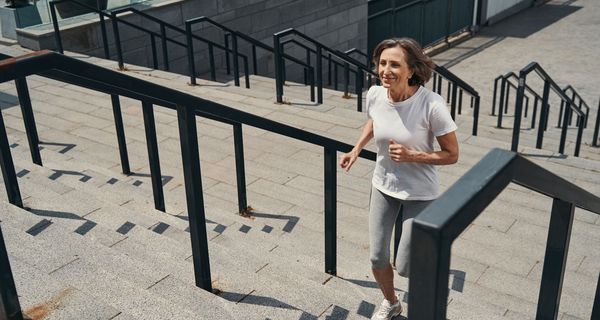 Frau, joggt eine Treppe hoch.