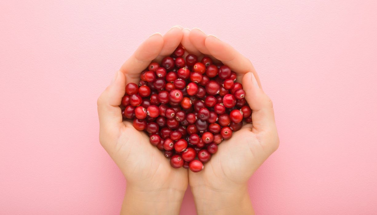 Frau, hält Cranberrys in ihrer Hand.