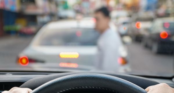 Fußgänger, läuft vor einem Auto über die Straße.