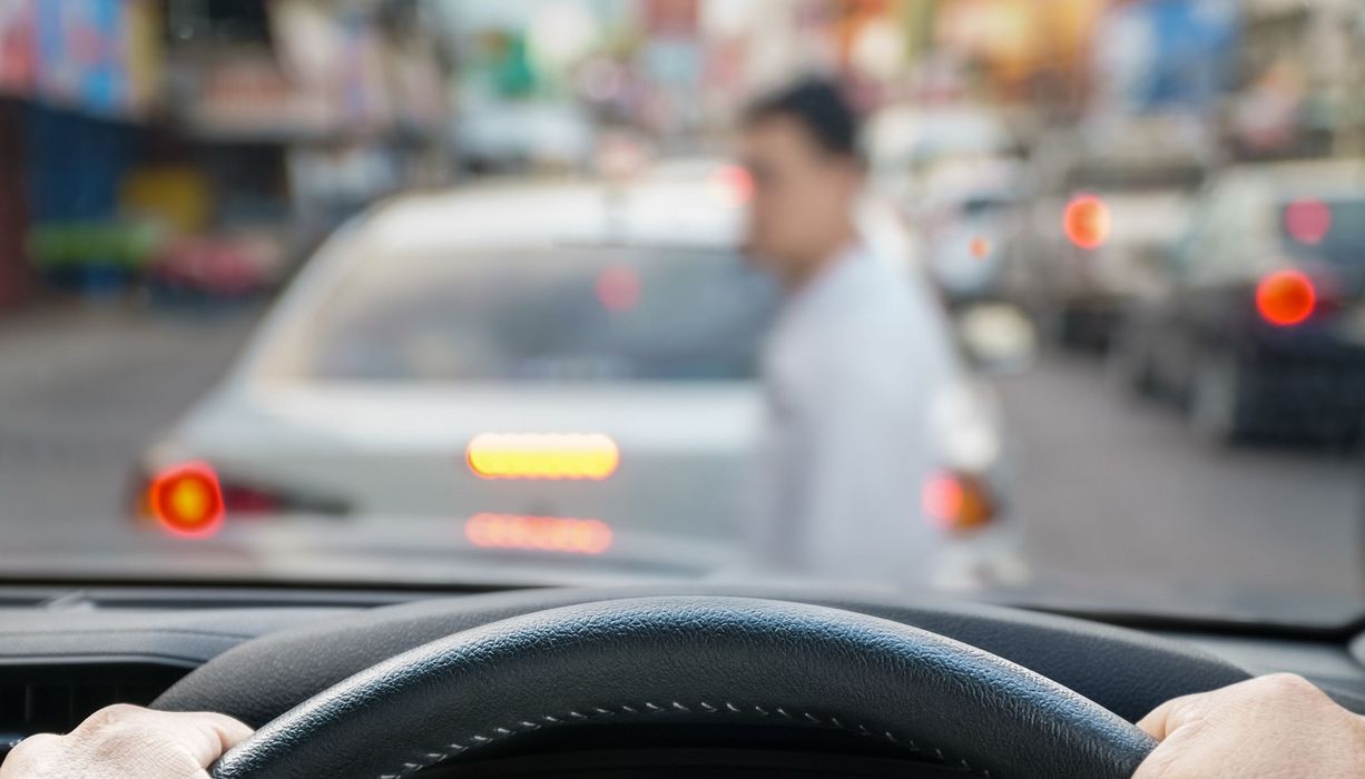 Fußgänger, läuft vor einem Auto über die Straße.