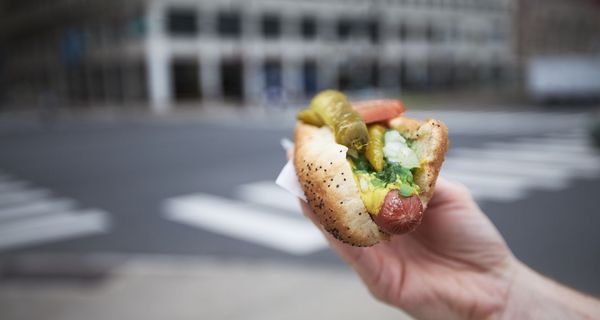 Frau, hält ein Hot Dog in der Hand.