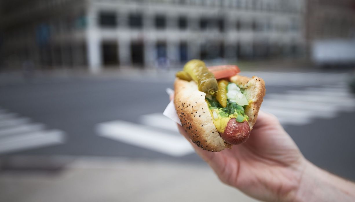 Frau, hält ein Hot Dog in der Hand.