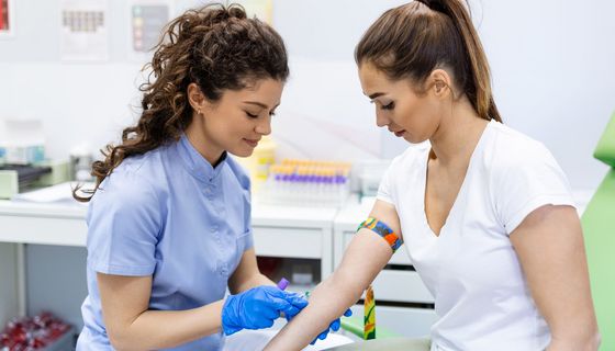 Medizinisches Fachpersonal nimmt einer Patientin Blut ab.