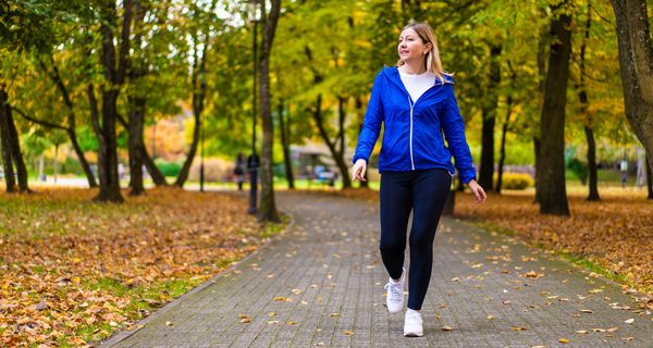 Junge Frau beim Walking im herbstlichen Stadtpark.