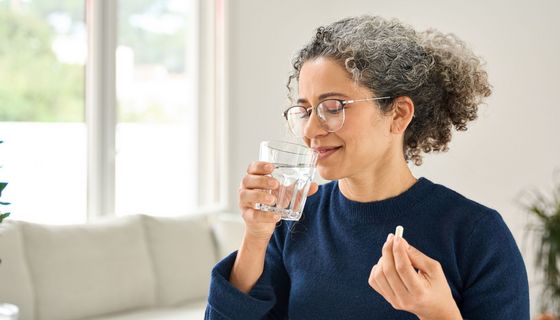 Frau nimmt Tablette ein.