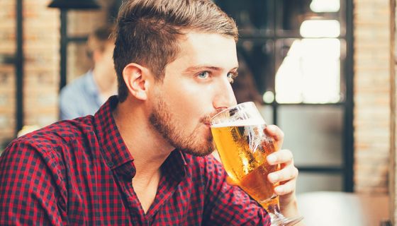 Junger Mann trinkt ein Glas Bier.