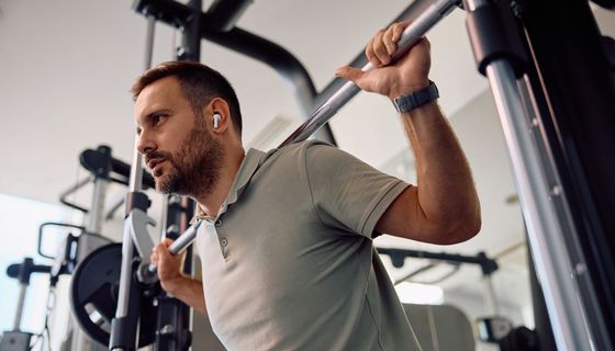 Mann beim Krafttraining mit großen Gewichten im Fitnessstudio.