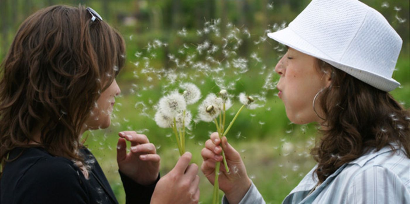 Zwei Frauen mit Pusteblumen