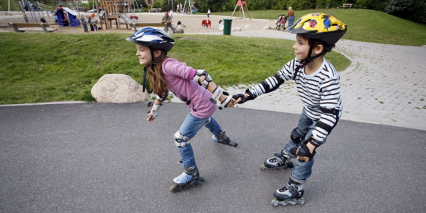 Zwei Kinder fahren Inliner.