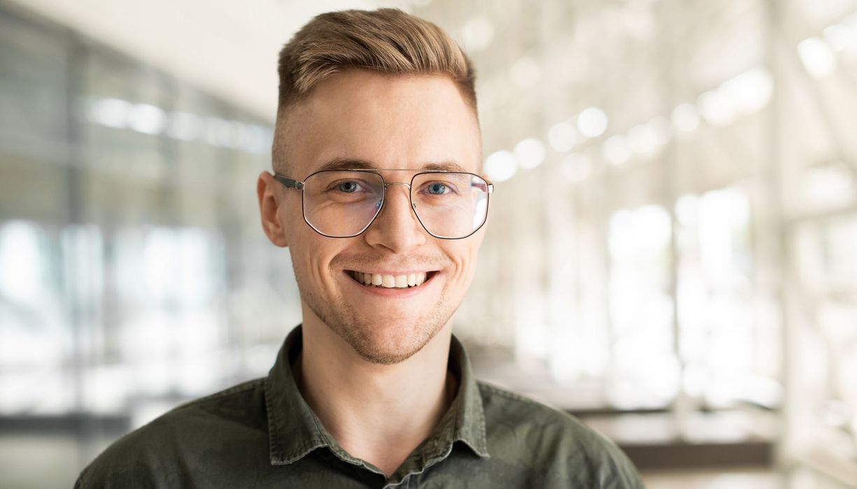 Junger Mann mit Brille blickt direkt den Betrachter direkt an.