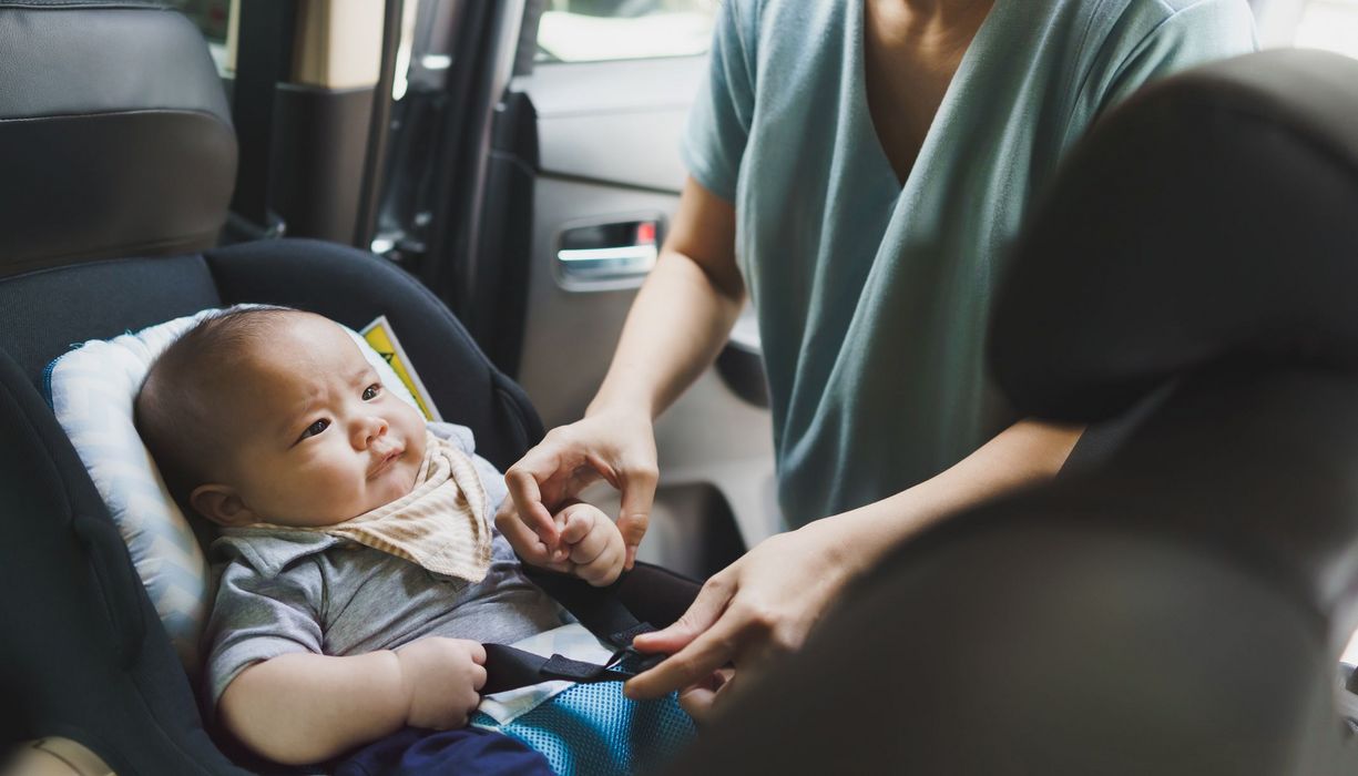 Baby in einem nach hinten gerichteten Autositz.