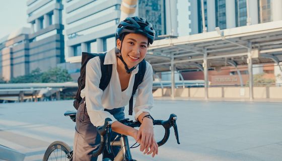 Junge Frau, auf dem Fahrrad auf dem Weg zur Arbeit.