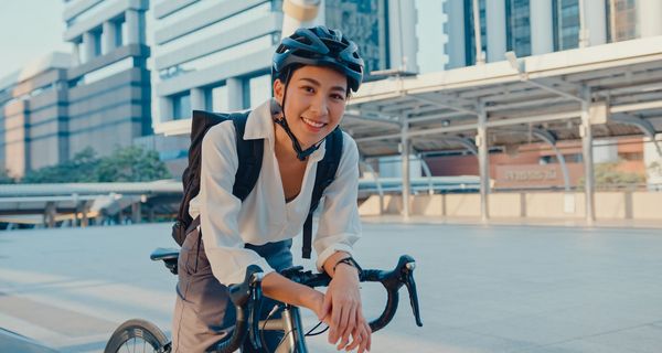 Junge Frau, auf dem Fahrrad auf dem Weg zur Arbeit.