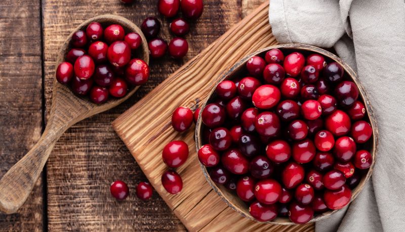 Cranberries auf einem braunen Holzuntergrund.