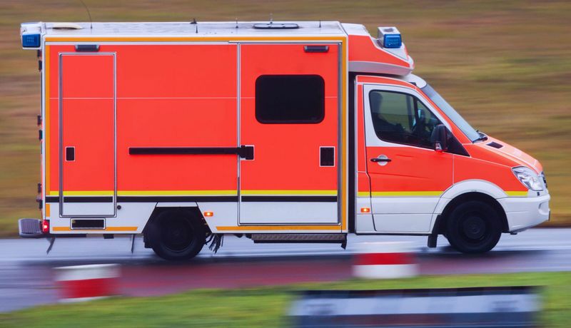 Ein Krankenwagen, der auf einer Landstraße unterwegs ist.
