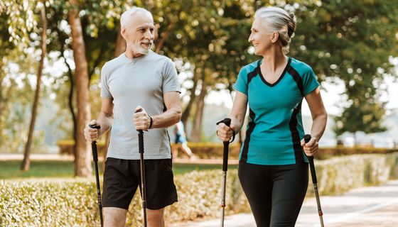 Ein älteres Paar walked gemeinsam durch einen Park.