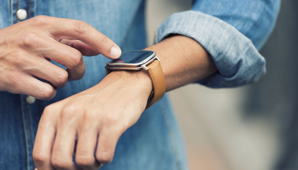 Junger Mann mit Smartwatch am Handgelenk.