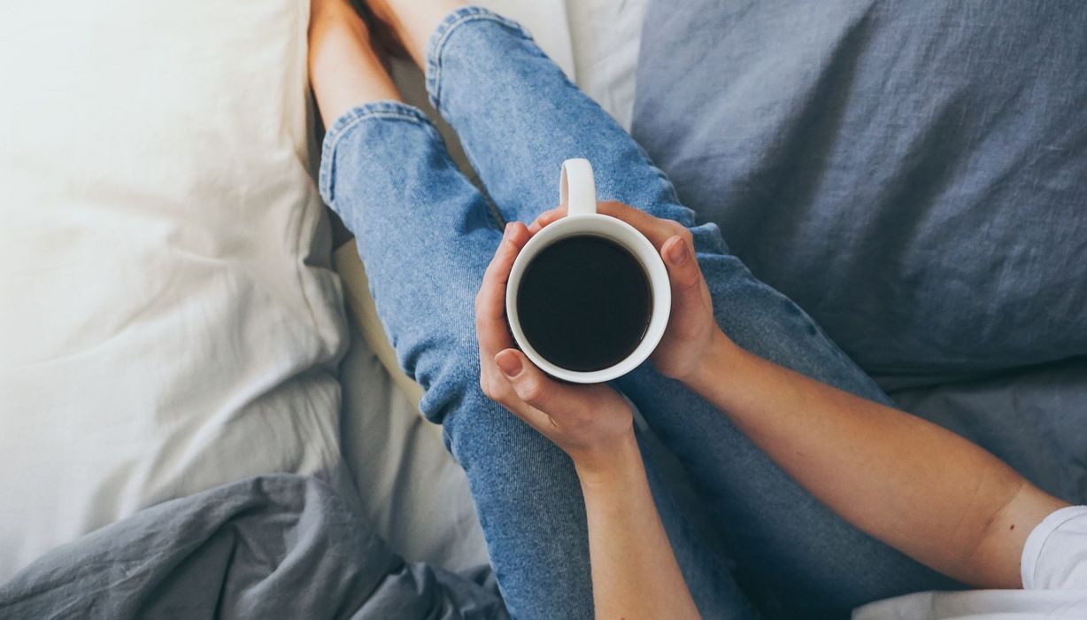 Frau, hält Kaffee in den Händen.