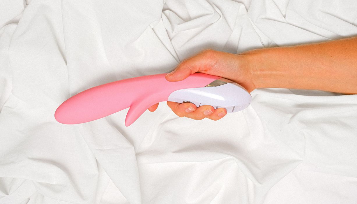 Frau, hält einen Vibrator in der Hand.