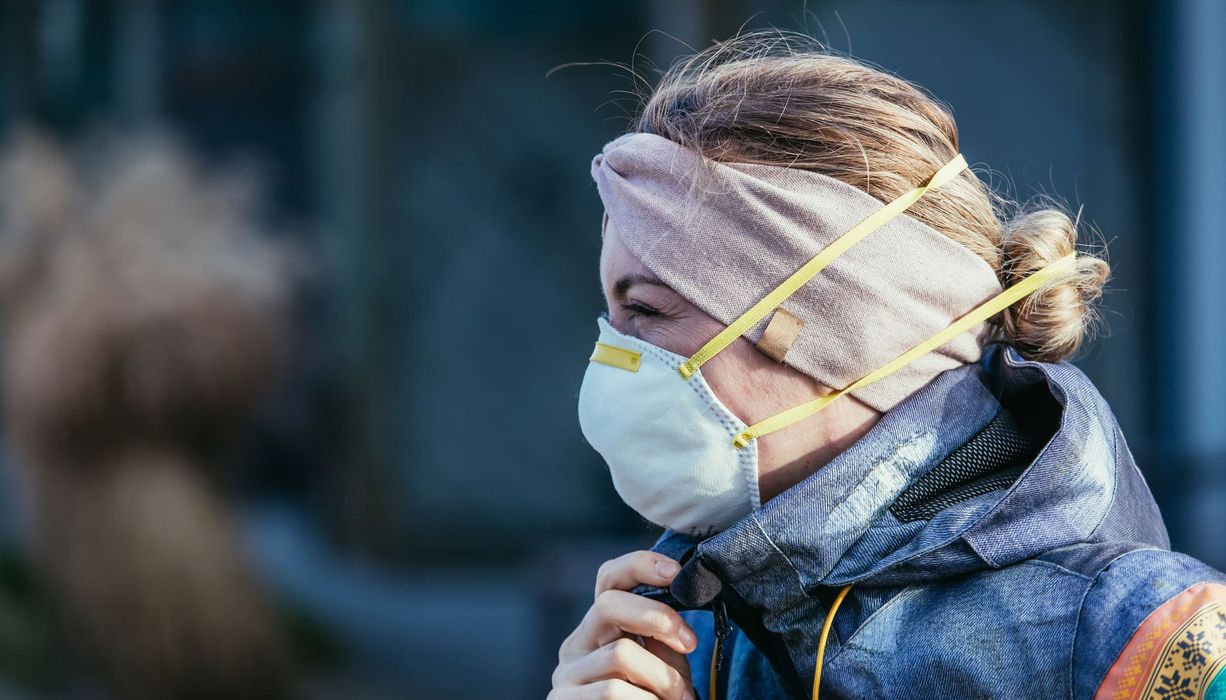 Junge Frau mit Stirnband und FFP2-Maske.