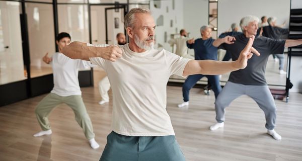 Gruppe, übt Qigong zusammen in einer Sporthalle.