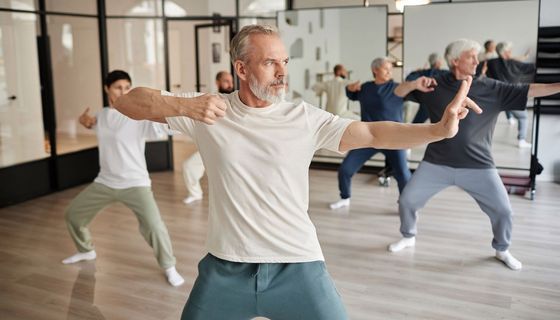 Gruppe, übt Qigong zusammen in einer Sporthalle.