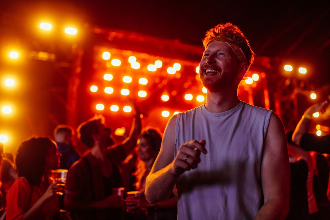 Junger Mann, glücklich bei einem Konzert.