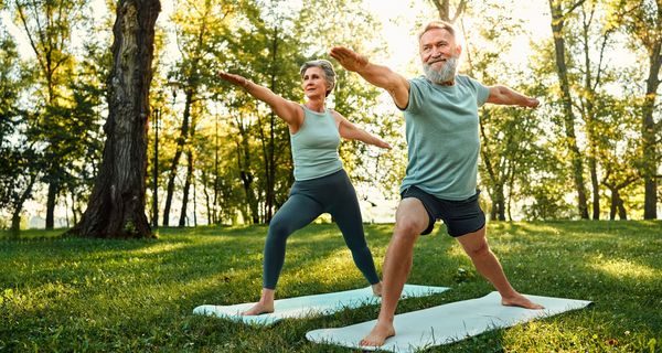 Zwei Senioren, trainieren Yoga im Park.