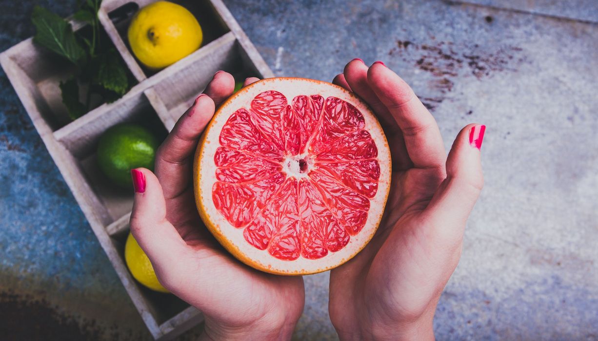 Junge Frau, hält Grapefruit in den Händen.