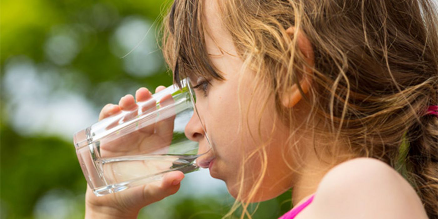 Nahaufnahme Gesicht Mädchen im Profil, nasse Haare, Ansatz Badeanzug, beim Wassertrinken aus Glas