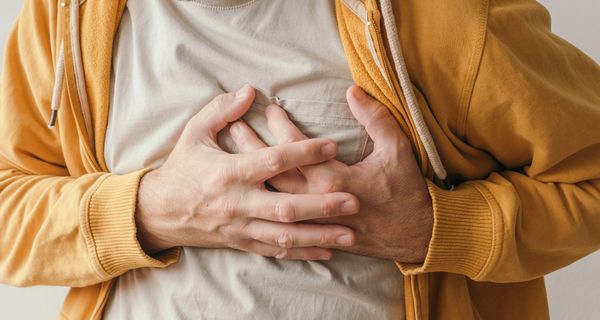 Mann, hält seine Hand an die Brust.