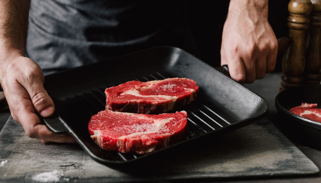 Mann bereitet Rindfleisch zu.